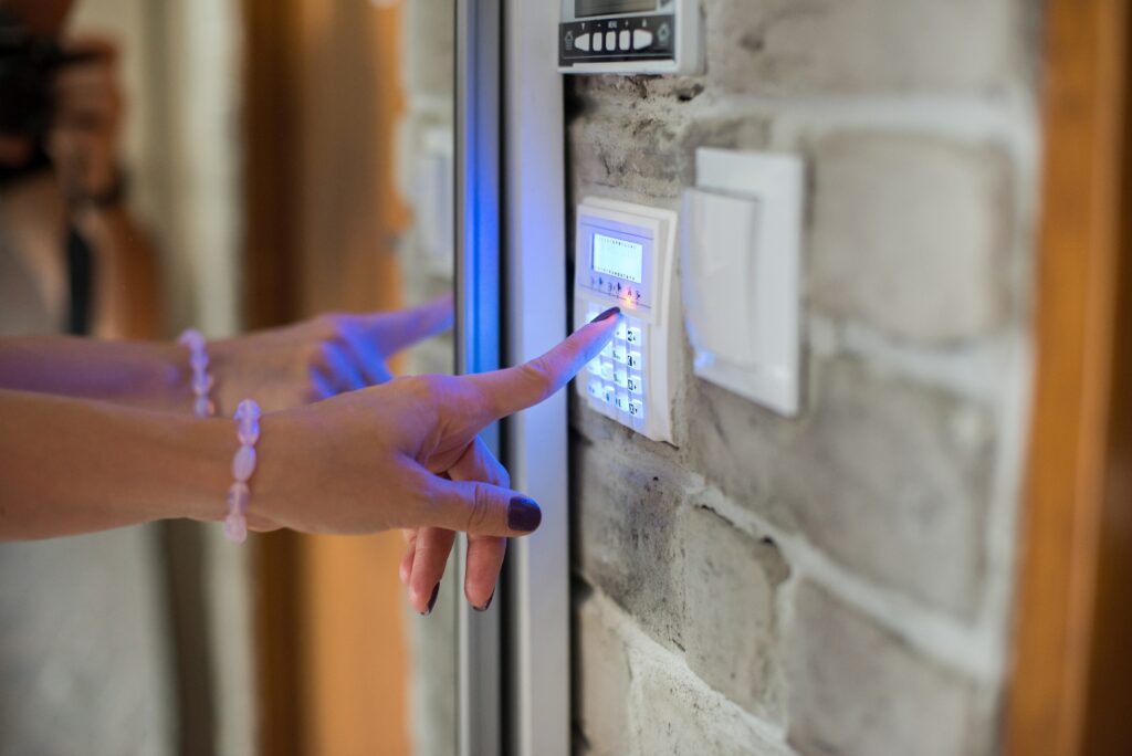 Picture of a burglar alarm being activated by woman