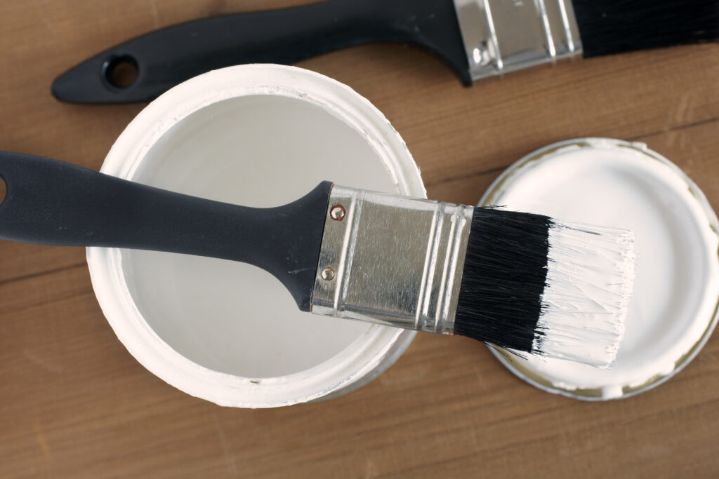 Picture of a pot of white paint with paintbrush