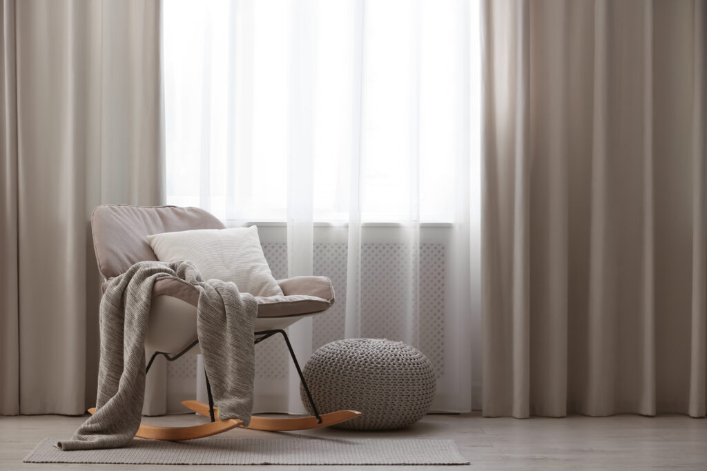 Picture of a chair with window and long curtains in beige