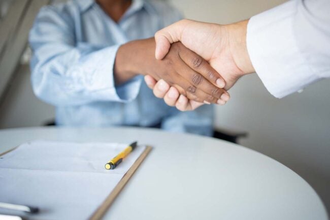 A close up of two people shaking hands. 