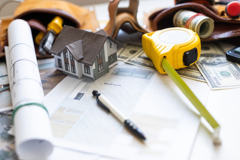 a model house on blueprints with keys to the new home close up high quality photo