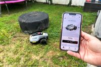 A person controls the MAMMOTION YUKA mini (H Version) Perimeter Wire-Free Robot Lawn Mower with a smartphone