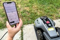 A person pairs their smartphone with the MAMMOTION YUKA mini (H Version) Perimeter Wire-Free Robot Lawn Mower