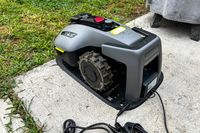 The MAMMOTION YUKA mini (H Version) Perimeter Wire-Free Robot Lawn Mower charges in a charging station