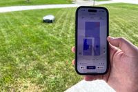 A person controls the ANTHBOT Genie 3000 Smart AI Robot Lawn Mower with their smartphone