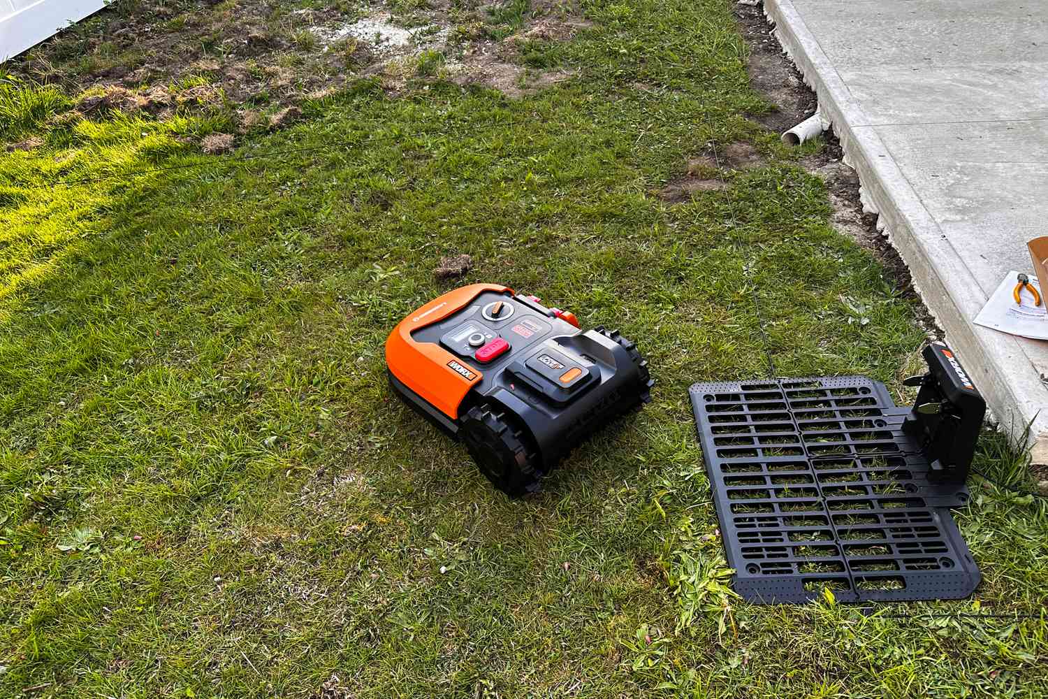 The WORX WR147 Landroid Robotic Lawn Mower cuts a small patch of grass