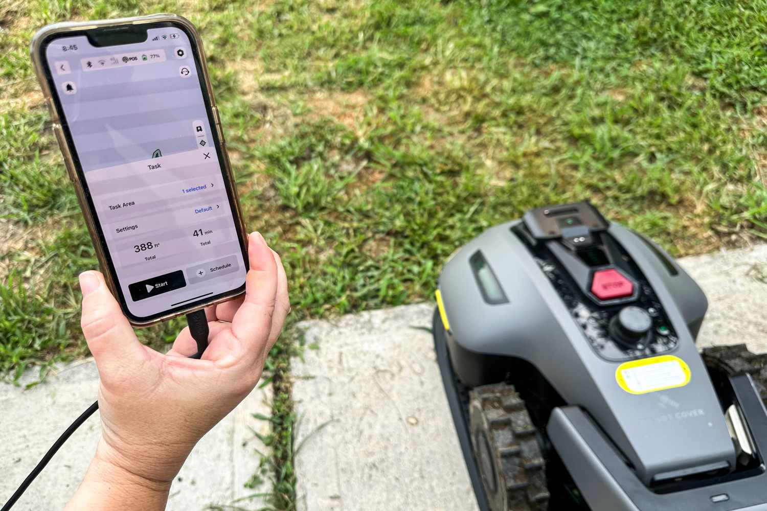A person pairs their smartphone with the MAMMOTION YUKA mini (H Version) Perimeter Wire-Free Robot Lawn Mower